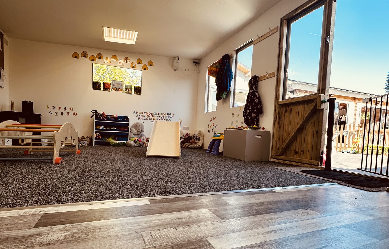 Cabin playroom with doors opening onto the garden at Stewart Street nursery, Crewe